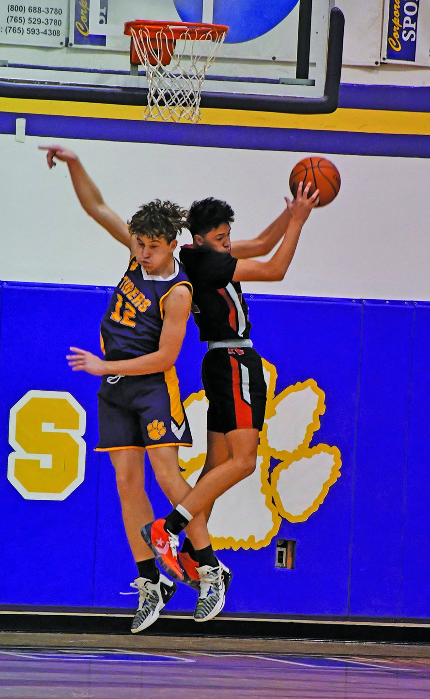 Two high school basketball players competing for the ball